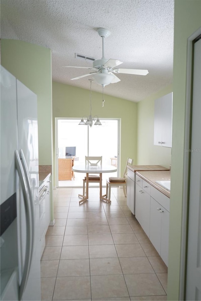 2325 Brookfield Greens Cir Unit 41, Sun City Center, FL 33573 - kitchen featuring white fridge with ice dispenser, white cabinets, ceiling fan, a textured ceiling, and light countertops