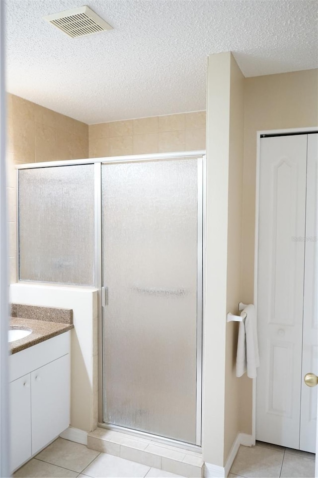 2325 Brookfield Greens Cir Unit 41, Sun City Center, FL 33573 - full bathroom with tile patterned floors, a shower stall, vanity, and a textured ceiling