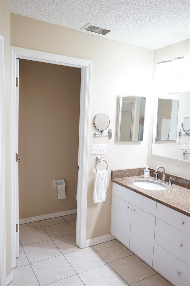 2325 Brookfield Greens Cir Unit 41, Sun City Center, FL 33573 - bathroom with tile patterned flooring, vanity, a textured ceiling, baseboards, and toilet