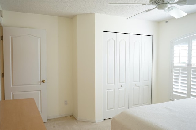 2325 Brookfield Greens Cir Unit 41, Sun City Center, FL 33573 - bedroom featuring light colored carpet, a closet, a textured ceiling, baseboards, and a ceiling fan