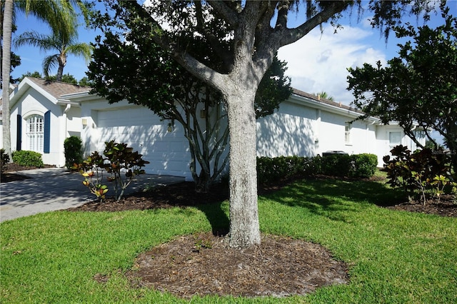 2325 Brookfield Greens Cir Unit 41, Sun City Center, FL 33573 - view of side of property with a garage, a lawn, stucco siding, and concrete driveway