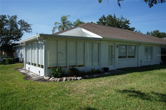 2325 Brookfield Greens Cir Unit 41, Sun City Center, FL 33573 - view of side of property with a sunroom, a lawn, and central AC