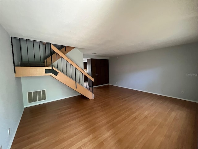 14667 Pine Glen Crk Unit 14667, Lutz, FL 33559 - unfurnished living room featuring wood finished floors, baseboards, and stairway