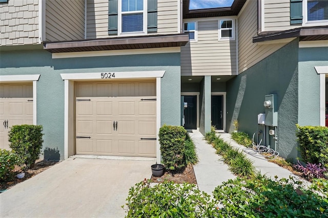 5024 Sylvester Loop, Tampa, FL 33610 - property entrance with stucco siding, an attached garage, and driveway