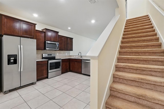 5024 Sylvester Loop, Tampa, FL 33610 - kitchen with stainless steel appliances, a sink, light countertops, dark brown cabinets, and decorative backsplash