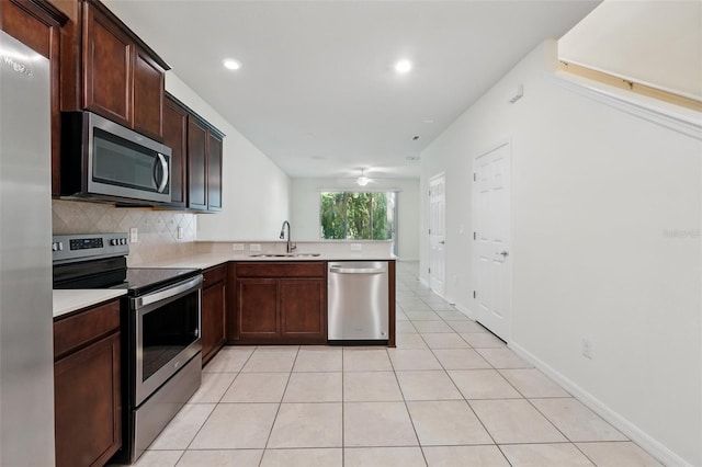 5024 Sylvester Loop, Tampa, FL 33610 - kitchen with appliances with stainless steel finishes, a sink, tasteful backsplash, light countertops, and light tile patterned flooring