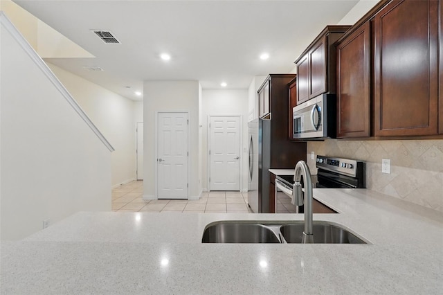 5024 Sylvester Loop, Tampa, FL 33610 - kitchen with stainless steel appliances, a sink, backsplash, light tile patterned flooring, and recessed lighting