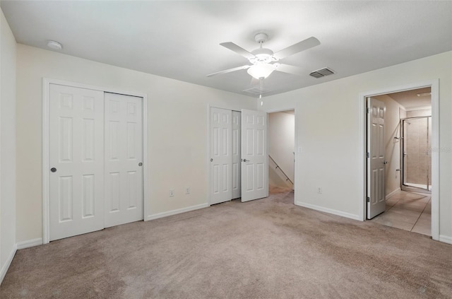 5024 Sylvester Loop, Tampa, FL 33610 - unfurnished bedroom with two closets, carpet floors, baseboards, ensuite bathroom, and ceiling fan