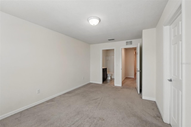 5024 Sylvester Loop, Tampa, FL 33610 - unfurnished bedroom featuring light carpet, baseboards, and ensuite bath