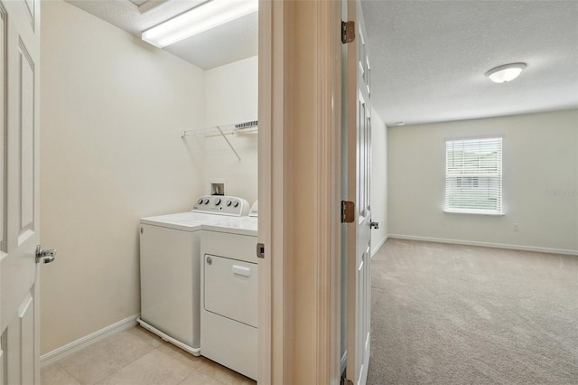 5024 Sylvester Loop, Tampa, FL 33610 - laundry area featuring washing machine and clothes dryer, baseboards, a textured ceiling, and light carpet