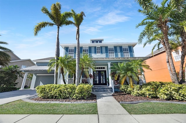 5225 Brighton Shore Dr, Apollo Beach, FL 33572 - view of front of home featuring covered porch, french doors, stucco siding, and concrete driveway