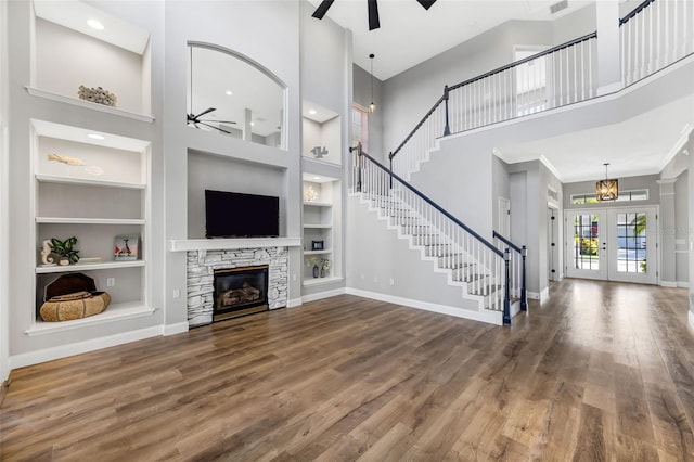 5225 Brighton Shore Dr, Apollo Beach, FL 33572 - unfurnished living room featuring ceiling fan, a towering ceiling, built in features, baseboards, and wood finished floors