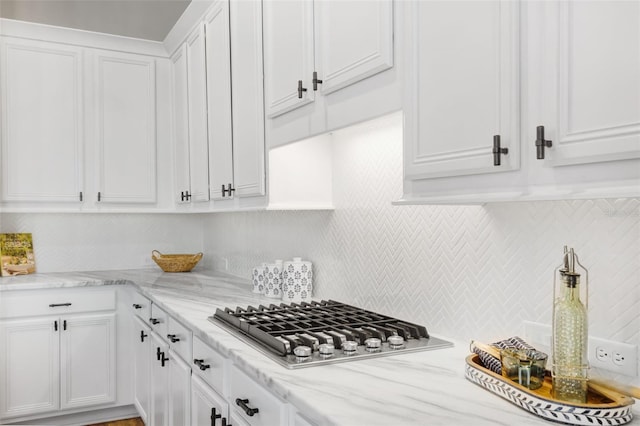 5225 Brighton Shore Dr, Apollo Beach, FL 33572 - kitchen with stainless steel gas stovetop, white cabinets, backsplash, and light stone counters
