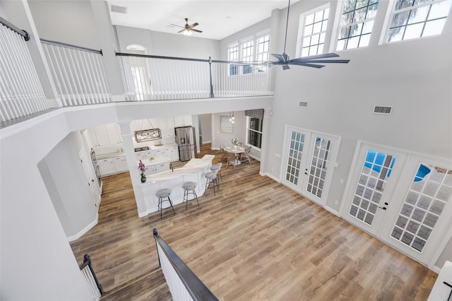 5225 Brighton Shore Dr, Apollo Beach, FL 33572 - living room featuring a ceiling fan, french doors, a high ceiling, wood finished floors, and baseboards