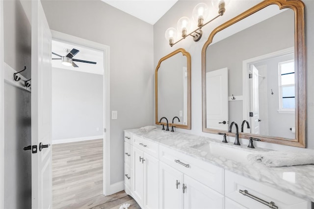 5225 Brighton Shore Dr, Apollo Beach, FL 33572 - bathroom featuring double vanity, wood finished floors, baseboards, and ceiling fan