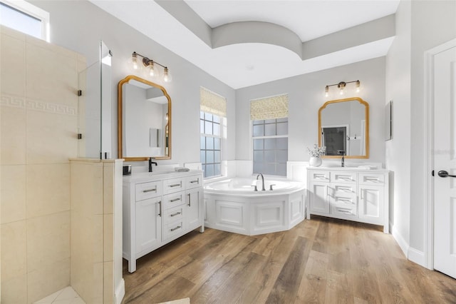 5225 Brighton Shore Dr, Apollo Beach, FL 33572 - bathroom with a bath, two vanities, wood finished floors, and tiled shower