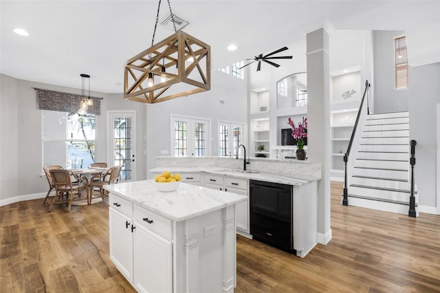 5225 Brighton Shore Dr, Apollo Beach, FL 33572 - kitchen with a sink, black dishwasher, a center island, white cabinetry, and wood finished floors