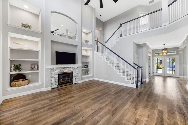 5225 Brighton Shore Dr, Apollo Beach, FL 33572 - unfurnished living room with a ceiling fan, a towering ceiling, built in shelves, wood finished floors, and stairway