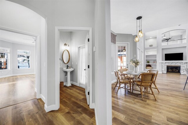 5225 Brighton Shore Dr, Apollo Beach, FL 33572 - hallway with built in features, healthy amount of natural light, wood finished floors, and arched walkways
