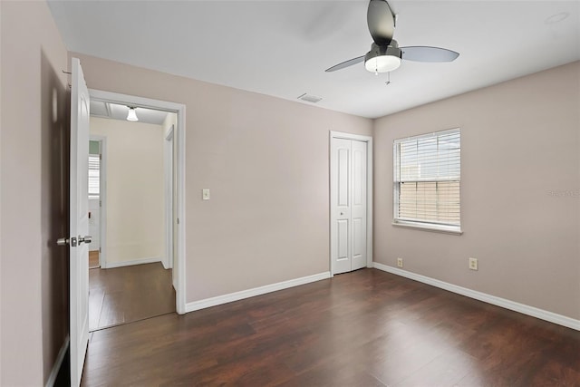 6183 5th Ave S, Saint Petersburg, FL 33707 - unfurnished bedroom featuring dark wood-type flooring, baseboards, a closet, and ceiling fan