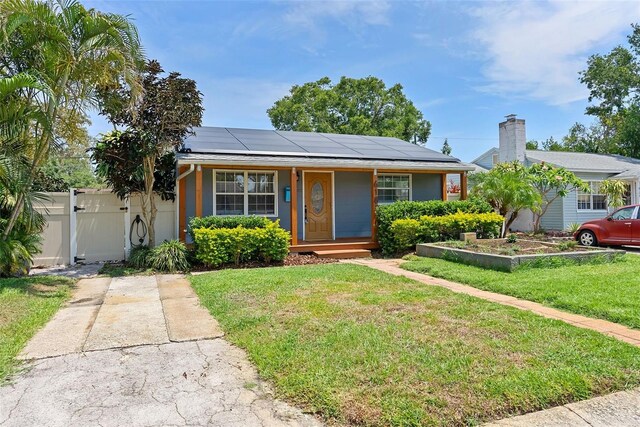 6183 5th Ave S, Saint Petersburg, FL 33707 - bungalow featuring a porch, roof mounted solar panels, and a gate