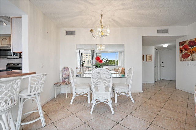 6269 Palma Del Mar Blvd S Unit 306, Saint Petersburg, FL 33715 - dining space with a chandelier, light tile patterned flooring, baseboards, and a textured ceiling