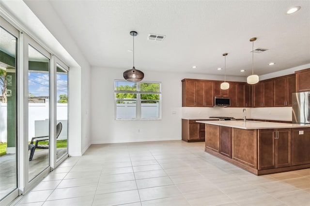 511 Roanoke St, Dunedin, FL 34698 - kitchen featuring stainless steel appliances, light countertops, light tile patterned floors, hanging light fixtures, and recessed lighting