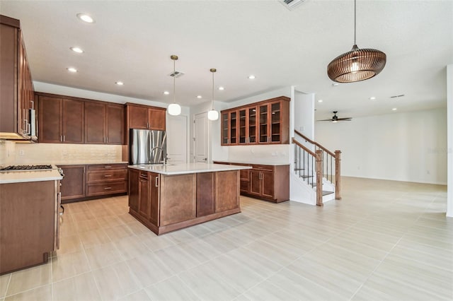 511 Roanoke St, Dunedin, FL 34698 - kitchen with freestanding refrigerator, recessed lighting, light countertops, backsplash, and a kitchen island with sink