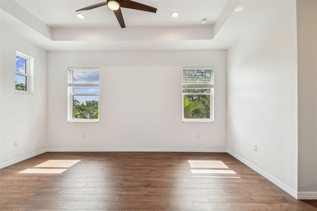 511 Roanoke St, Dunedin, FL 34698 - empty room with hardwood / wood-style flooring, ceiling fan, a raised ceiling, baseboards, and recessed lighting