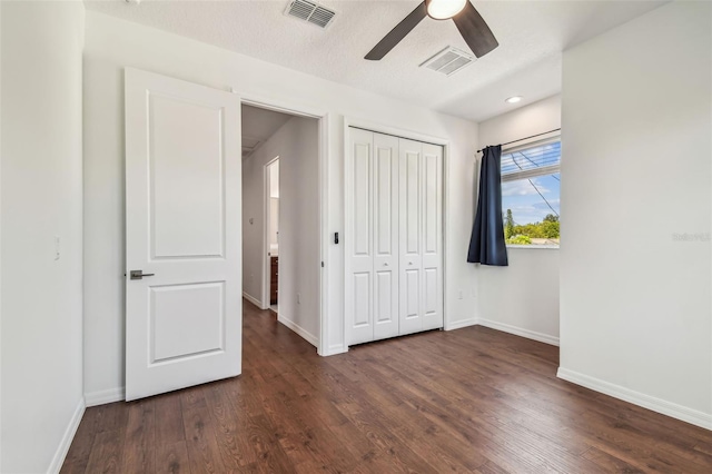 511 Roanoke St, Dunedin, FL 34698 - unfurnished bedroom featuring baseboards, dark wood-style floors, and a closet