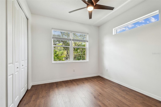 511 Roanoke St, Dunedin, FL 34698 - unfurnished bedroom with dark wood-style flooring, a closet, baseboards, and ceiling fan