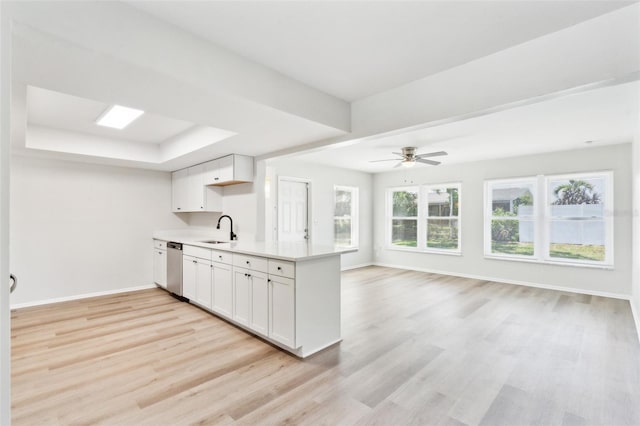 315 Dorchester Dr, Venice, FL 34293 - kitchen featuring light countertops, light wood finished floors, a sink, baseboards, and a tray ceiling