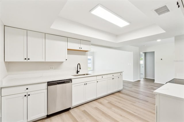 315 Dorchester Dr, Venice, FL 34293 - kitchen featuring dishwasher, a sink, a raised ceiling, light wood-style flooring, and white cabinetry