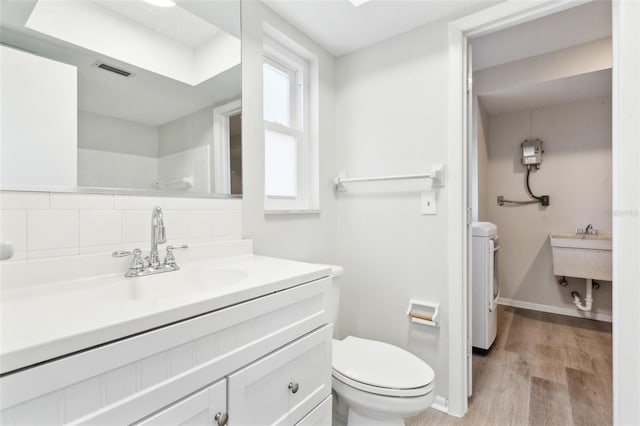 315 Dorchester Dr, Venice, FL 34293 - bathroom featuring separate washer and dryer, toilet, wood finished floors, vanity, and baseboards