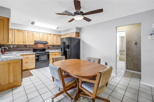 9674 104th Ave, Largo, FL 33773 - kitchen with black appliances, under cabinet range hood, a sink, light tile patterned flooring, and decorative backsplash