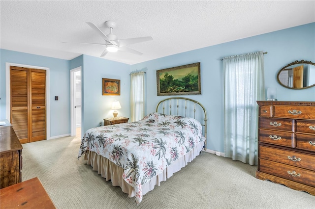 9674 104th Ave, Largo, FL 33773 - bedroom featuring light carpet, a closet, baseboards, a textured ceiling, and a ceiling fan