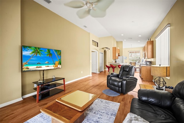 31108 Whitlock Dr, Wesley Chapel, FL 33543 - living room with baseboards, light wood finished floors, a ceiling fan, arched walkways, and recessed lighting