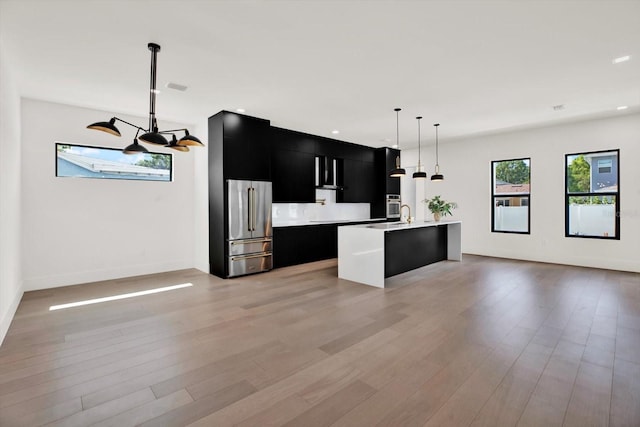 908 W Fribley St, Tampa, FL 33603 - kitchen featuring dark cabinetry, appliances with stainless steel finishes, modern cabinets, light countertops, and an island with sink