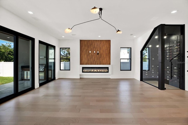 908 W Fribley St, Tampa, FL 33603 - unfurnished living room with healthy amount of natural light, wood finished floors, recessed lighting, and a glass covered fireplace
