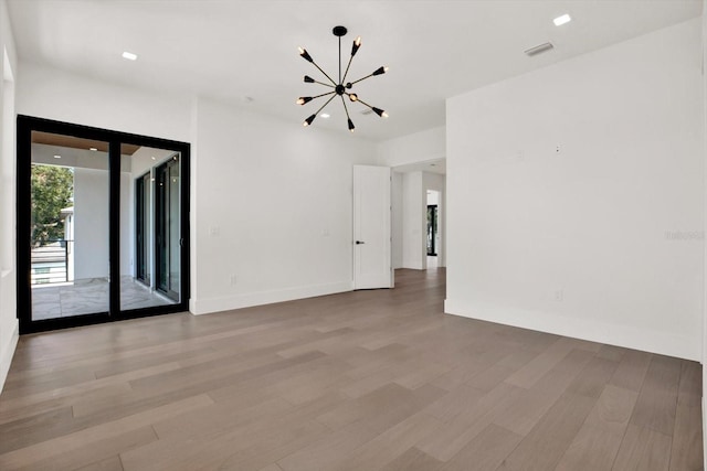 908 W Fribley St, Tampa, FL 33603 - unfurnished room with a chandelier, light wood finished floors, and baseboards