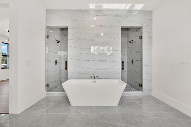 908 W Fribley St, Tampa, FL 33603 - bathroom with marble tiled floors, a freestanding bath, a marble finish shower, and baseboards
