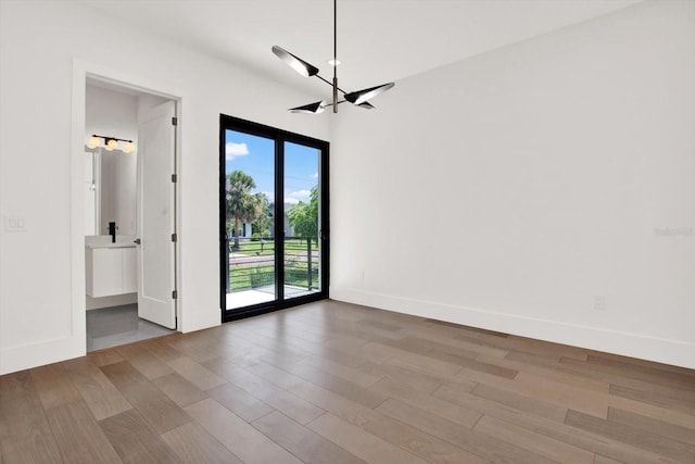908 W Fribley St, Tampa, FL 33603 - unfurnished room featuring a chandelier, wood finished floors, and baseboards