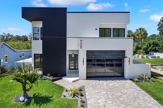 908 W Fribley St, Tampa, FL 33603 - contemporary house featuring decorative driveway, stucco siding, and an attached garage