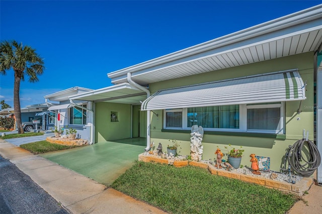 250 Rosery Rd NW Unit 218, Largo, FL 33770 - view of front of home featuring stucco siding, a carport, and concrete driveway