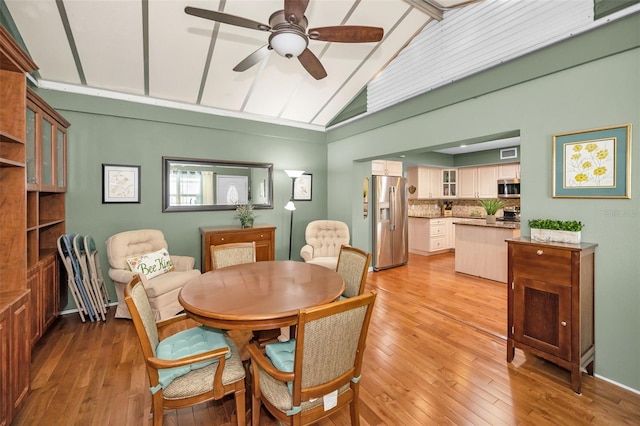 250 Rosery Rd NW Unit 218, Largo, FL 33770 - dining room with ceiling fan, light wood-style flooring, and high vaulted ceiling