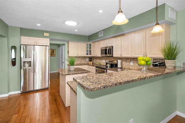250 Rosery Rd NW Unit 218, Largo, FL 33770 - kitchen featuring stainless steel appliances, dark stone countertops, backsplash, a center island, and a peninsula