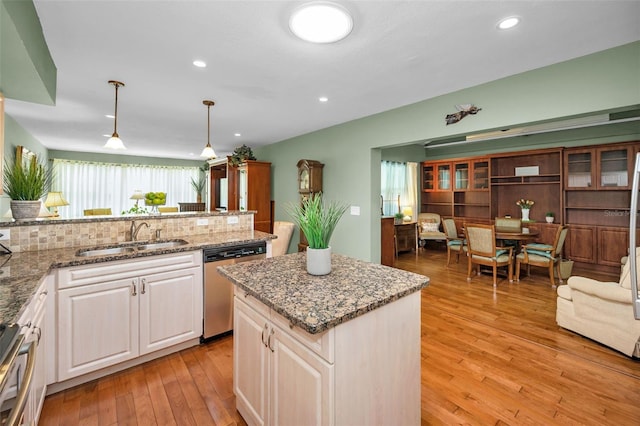 250 Rosery Rd NW Unit 218, Largo, FL 33770 - kitchen featuring stainless steel dishwasher, light stone countertops, light wood finished floors, a center island, and white cabinets