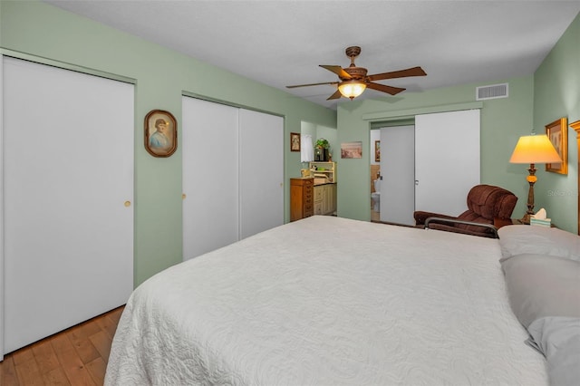 250 Rosery Rd NW Unit 218, Largo, FL 33770 - bedroom with two closets, hardwood / wood-style flooring, and a ceiling fan