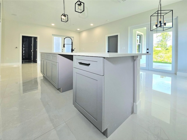 3115 52nd St W, Lehigh Acres, FL 33971 - kitchen with pendant lighting, a center island with sink, light countertops, light tile patterned floors, and a chandelier
