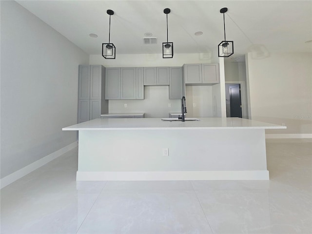 3115 52nd St W, Lehigh Acres, FL 33971 - kitchen featuring gray cabinetry, a sink, light tile patterned flooring, a large island, and baseboards